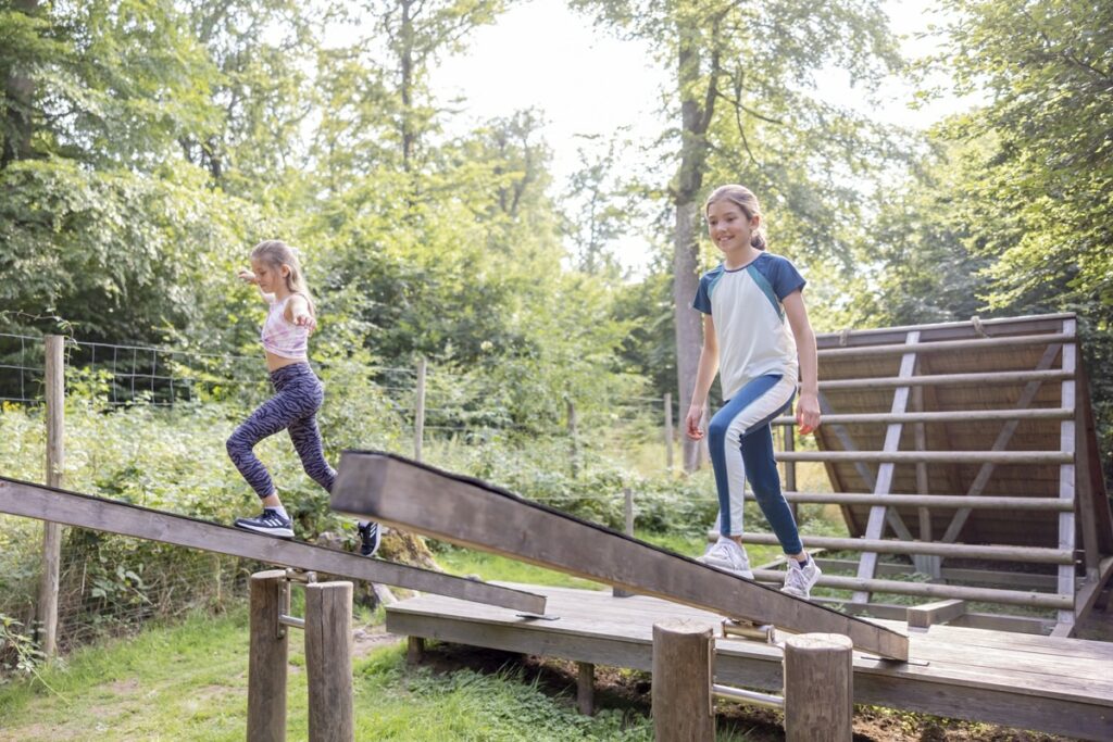 zwei Mädchen balancieren über eine Laufwippe im Arboretum Hindernisparcours | Foto: Hanna Witte