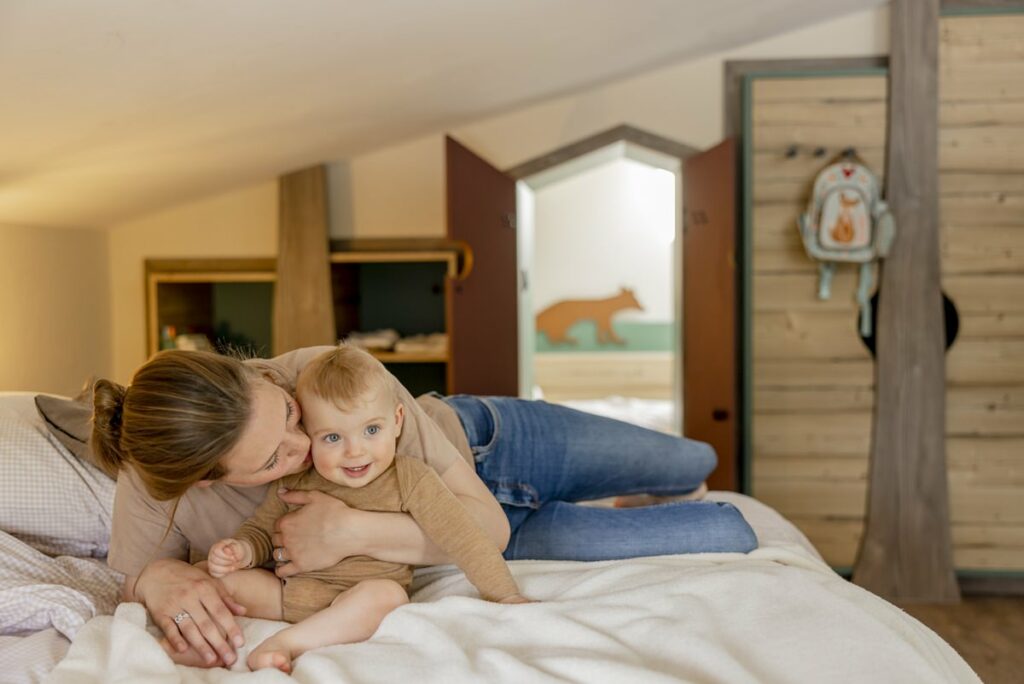 eine Mutter kuschelt mit ihrem Baby im Schlafzimmer eines Ferienhauses von Hof Hardthöhe | Foto: Hanna Witte
